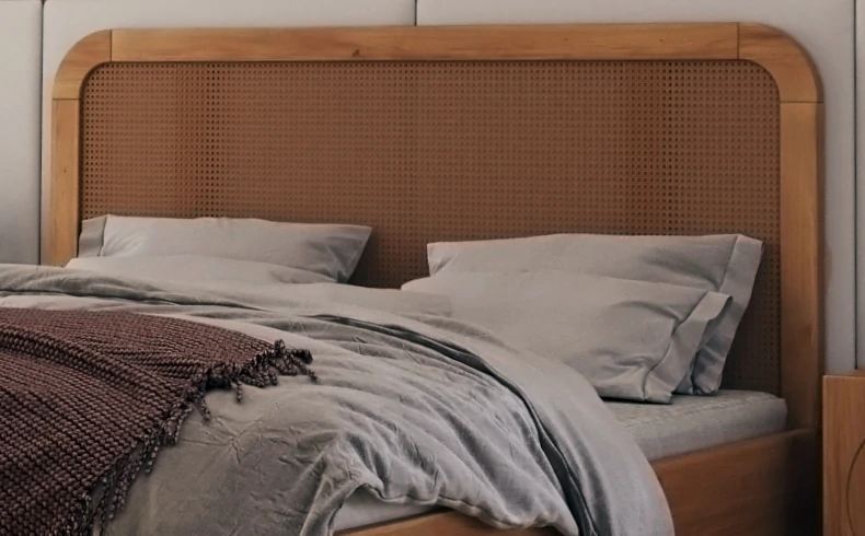 Drewniane łóżko z elementami rattanu na zagłówku