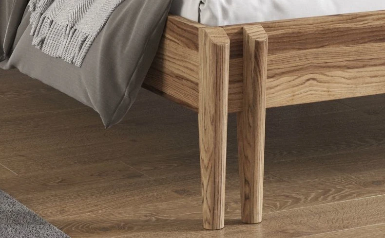 Drewniane łóżko z ozdobnym zagłówkiem