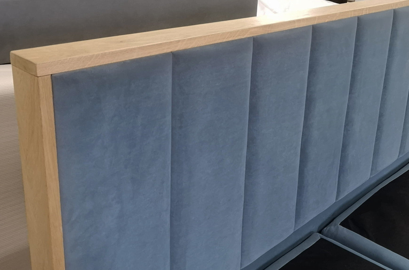 Tapicerowane łóżko kontynentalne LONDON z zagłówkiem z pionowymi przeszyciami i elementami drewna