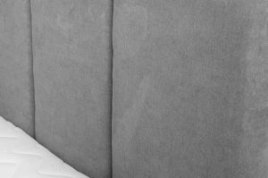 Tapicerowane łóżko do sypialni MALAR z pionowymi przeszyciami na zagłówku.